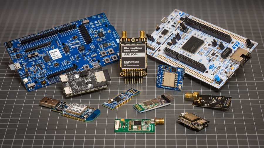 Collection of green, blue, white and black wireless boards without antennas on workbench